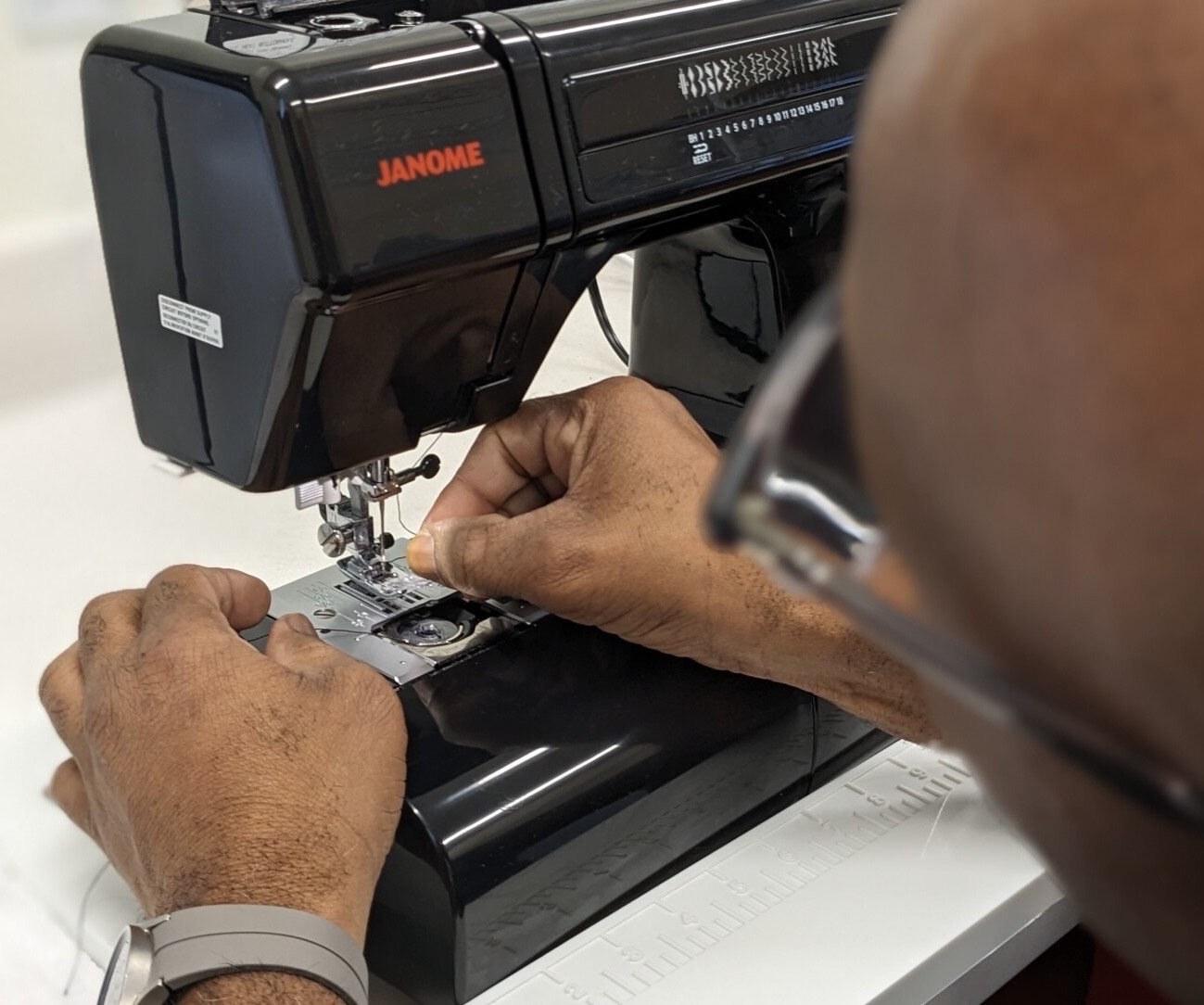Close-up of a person using a sewing machine